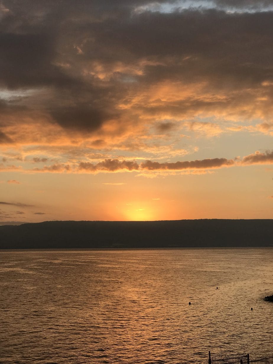 www.redneckrhapsody.com Sunrise on the Sea of Galilee - Shades of yellow. orange and peach doubles it's splendor by reflecting on the water and shading the clouds above.