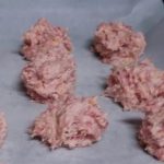 Sausage balls rolled up on pan ready for the oven.