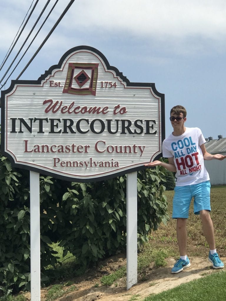www.redneckrhapsody.com Noah standing on the side of the road posing with the "Welcome to Intercourse, PA" sign