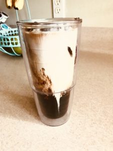 Iced coffee recipe poured together with cream and flavoring, ready to stir & drink.