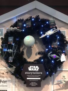 A black Christmas wreath at the Hallmark store with Star Wars ships all over it.