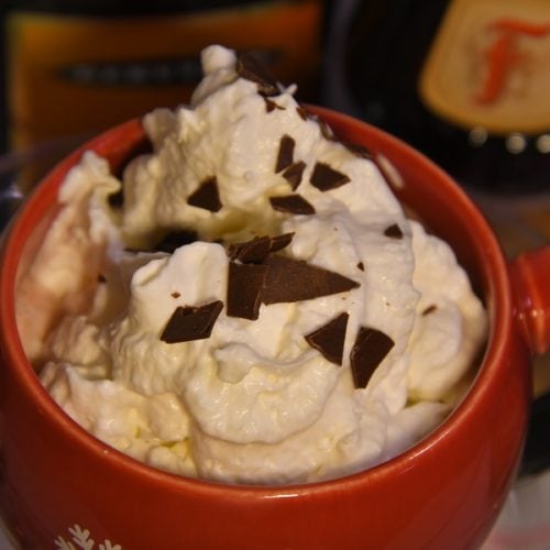 Southern Loaded Hot Chocolate - Close up cup full with whipped topping and chocolate chunks.