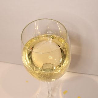 Perfect Peach Cocktail ready to sip on in a wine glass.