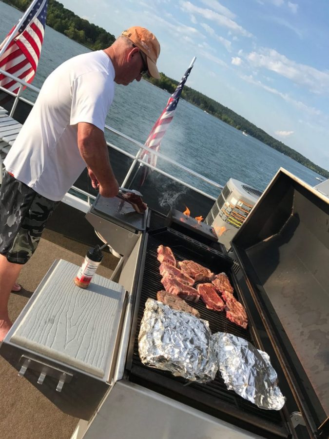 Robert grilling on Sikes Grill on top of the boat at Greers Ferry.