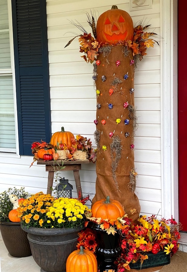 Fall decorations help this DIY Hollow Tree look festive and ready for Halloween.