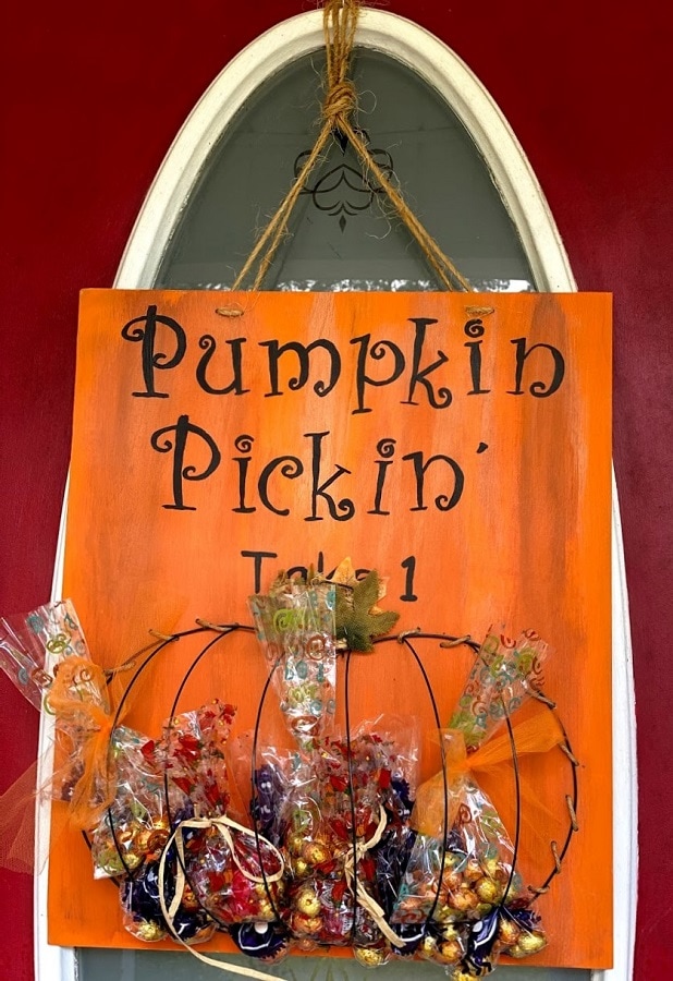 DIY Dollar Tree Pumpkin wire frame filled with treats bags of candy for trick or treating.