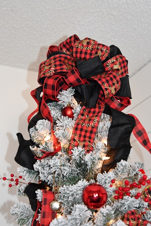 Black and Red Buffalo Plaid Bow Topper for decorating a flocked tree with red balls.