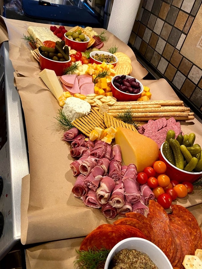 How to make a charcuterie board with cheese, meat, relish items, crackers, condiments and dip in dishes that's ready to serve.