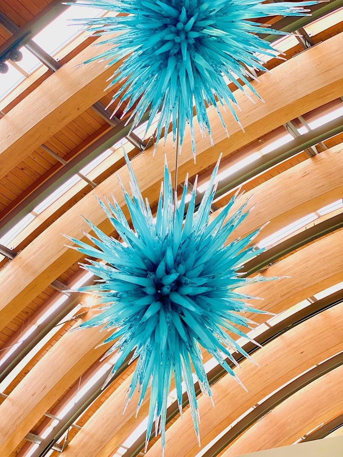 A beautiful Chihuly turquoise glass spike sphere hanging from the ceiling at Crystal Bridges.